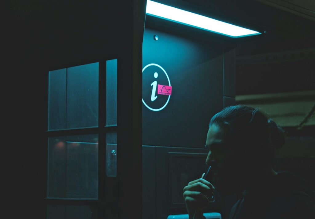 man talking on telephone booth